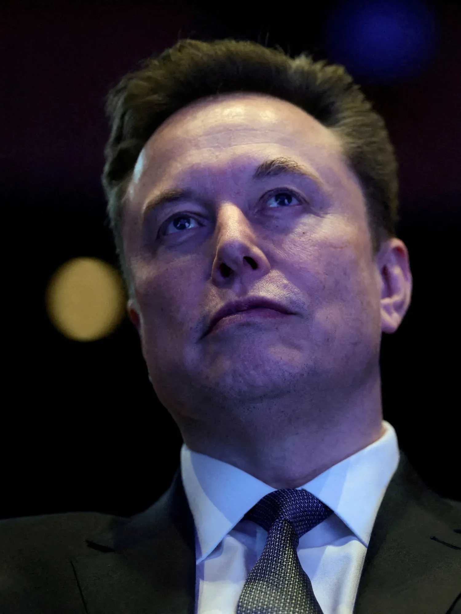 Elon Musk privind în sus, într-un mediu de conferință.