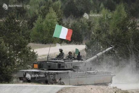 Tanc italian în mișcare, cu steagul Italiei fluturând pe fundalul pădurii.