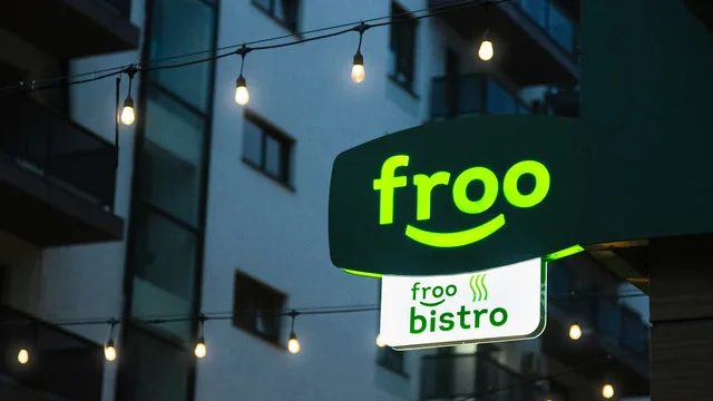 Signul unui magazin Froo iluminat noaptea, cu un design modern și prietenos.