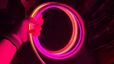 Banda luminoasă colorată, cu efecte de iluminare vibrante, în mână.