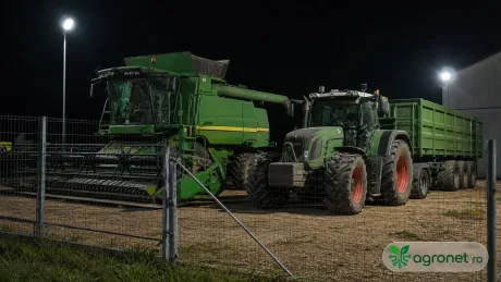 Tractoare și combine agricole pregătite pentru recoltare în noapte.