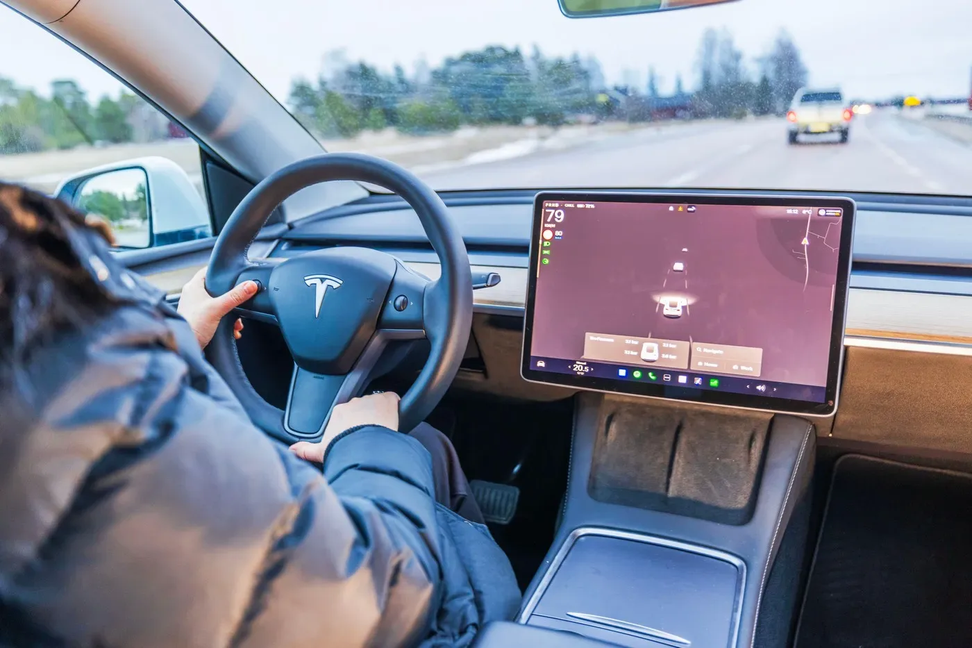 Interiorul unui vehicul electric cu ecran mare și volan modern.