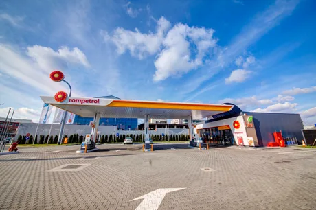 Stație de alimentare Rompetrol cu cer senin și nori pufoși.