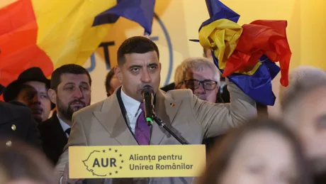 Un politician susține o inițiativă în fața mulțimii, cu steaguri românești în jur.