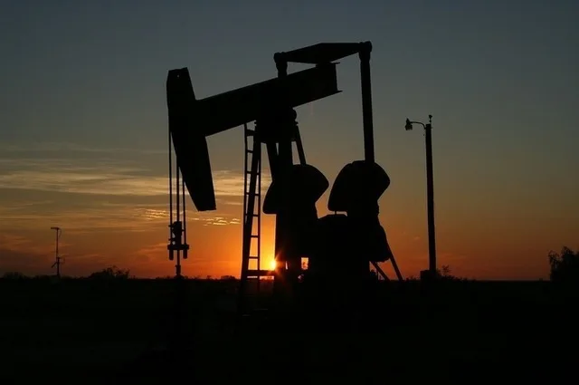 O pompă de petrol în apus, simbolizând creșterea prețurilor.
