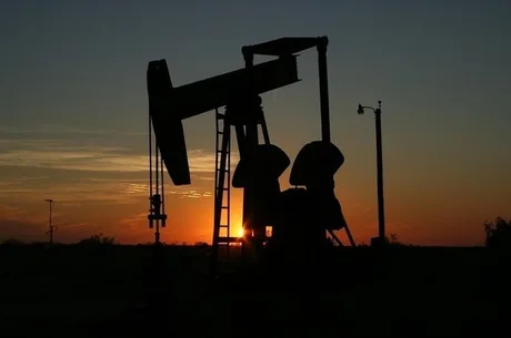 O pompă de petrol în apus, simbolizând creșterea prețurilor.