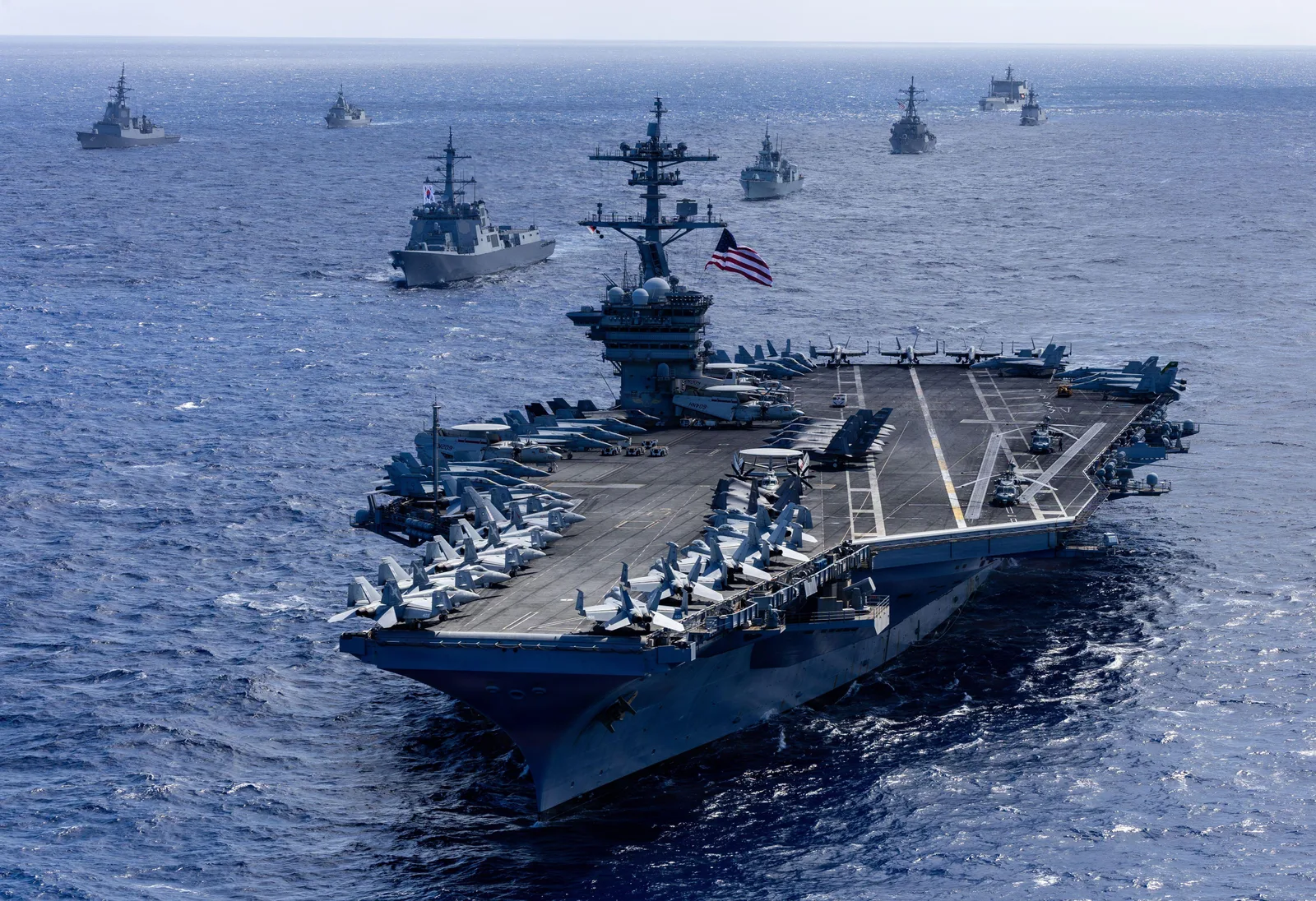 Portavionul USS Theodore Roosevelt navighează în apele din Orientul Mijlociu, alături de alte nave.