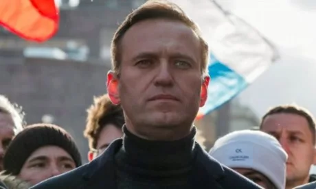 Aleksei Navalnîi la o manifestație, cu steaguri rusești în fundal.