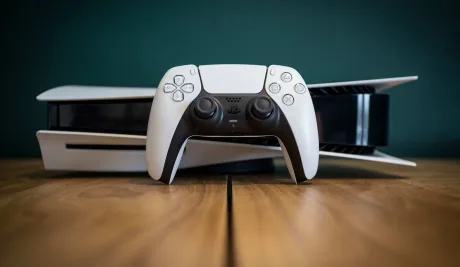 Console PlayStation 5 și controller pe un fundal de lemn.