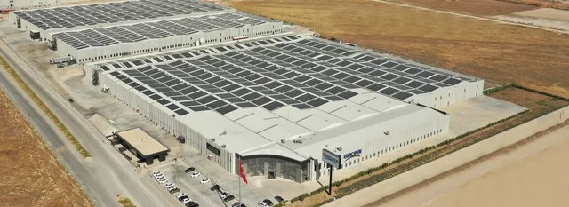 Fabrica de feronerie cu panouri solare în peisaj industrial românesc.