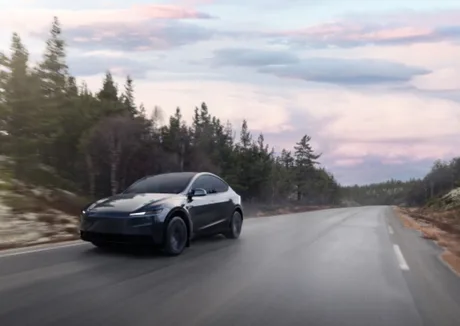 Tesla Model Y pe drum, înconjurat de natură și peisaje frumoase.