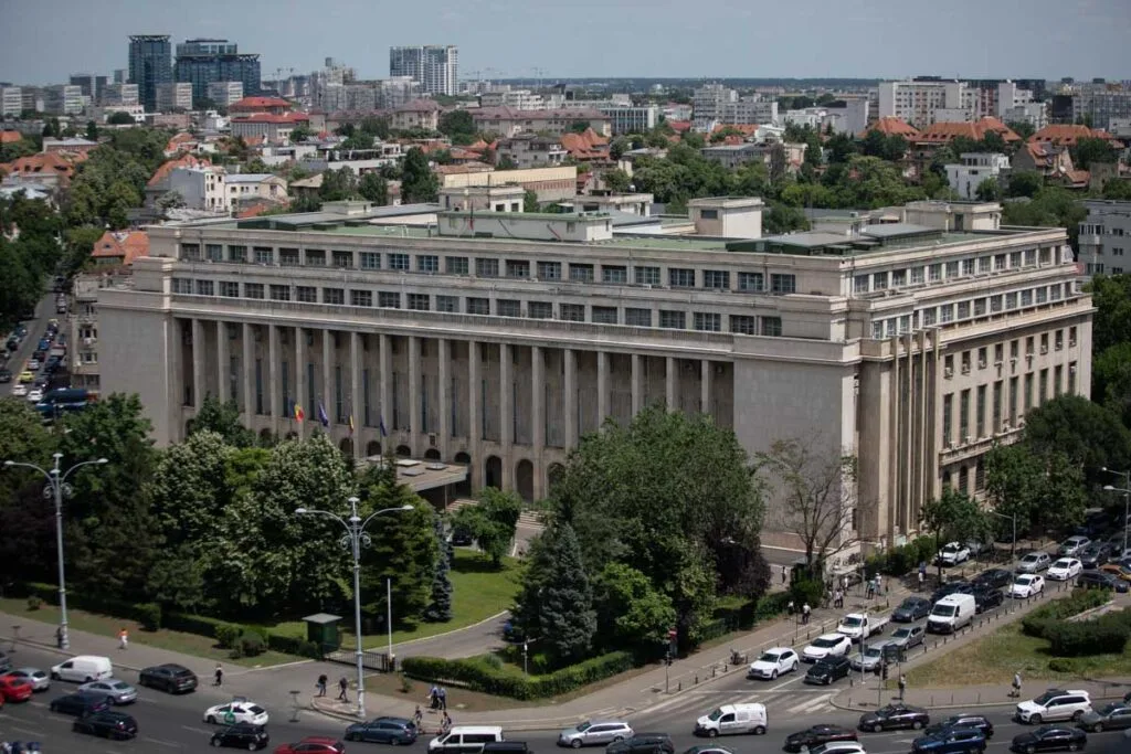 Clădirea Cancelariei Prim-ministrului în centrul orașului, cu vegetație și trafic.