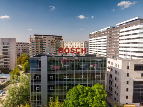 Clădirea Bosch în România, cu un peisaj urban modern în fundal.