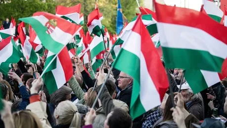 Oameni cu steaguri ungurești la un protest, exprimând nemulțumiri economice.