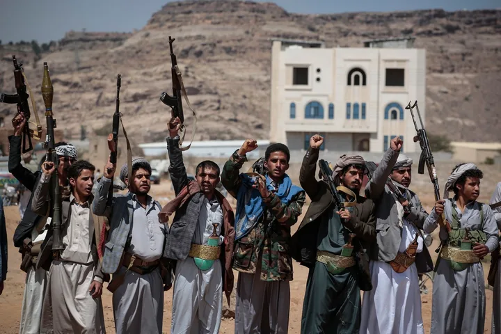 Rebelii Houthi protestează cu arme în mâini, în Yemen.