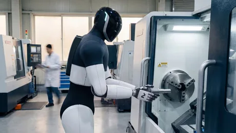 Un robot avansat interacționează cu o mașină de prelucrat în fabrică.