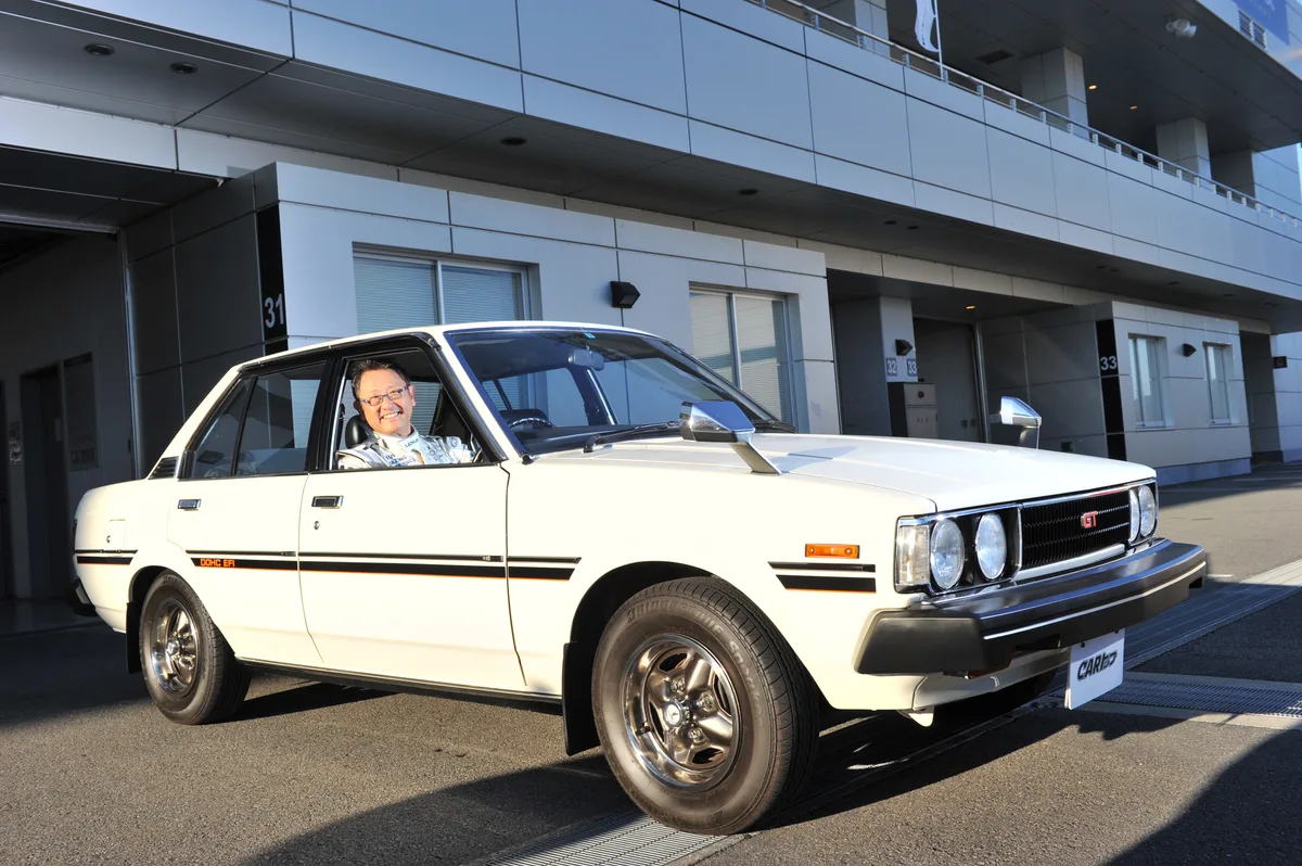 Akio Toyoda în fața unei mașini Toyota clasice, simbol al tradiției companiei.