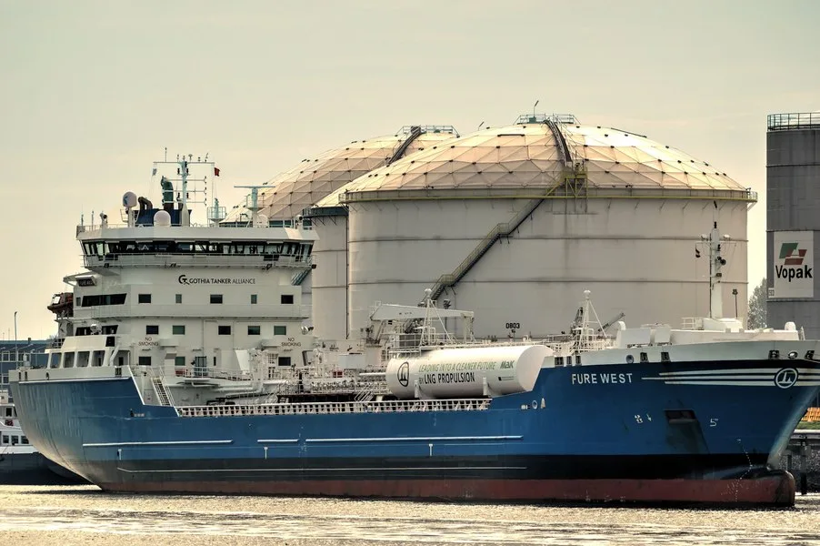 Vapor de transport maritim lângă rezervoare de petrol, simbolizând criza energetică.