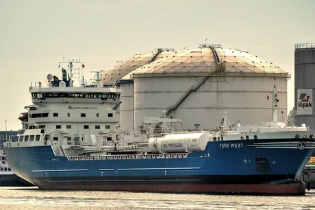 Vapor de transport maritim lângă rezervoare de petrol, simbolizând criza energetică.