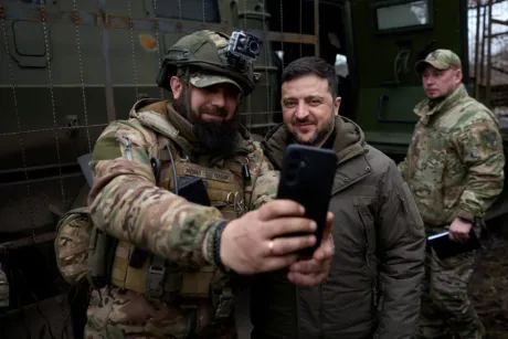 Un soldat ucrainean și un oficial fac o fotografie împreună pe front.
