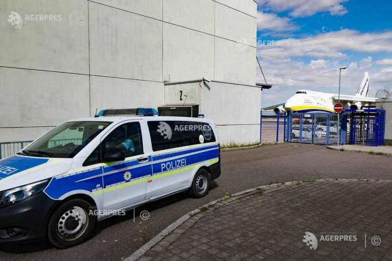 Mașină de poliție lângă aeroport, cu un avion în fundal.
