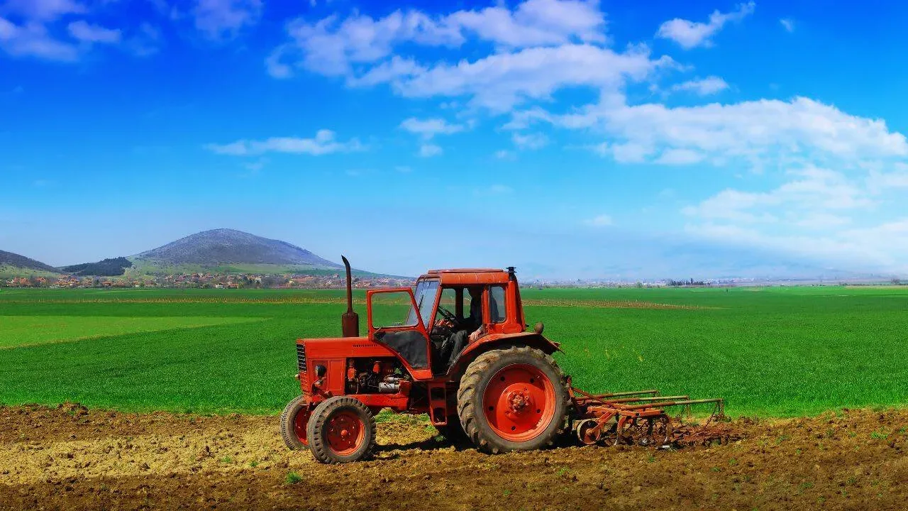 Tractor pe câmp, simbolizând agricultura românească fragmentată.