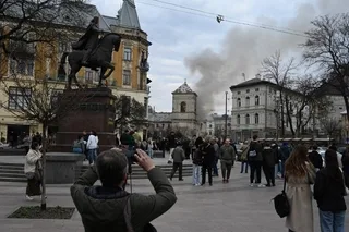 Oamenii observă fumul de la incidentul cu drona în oraș.