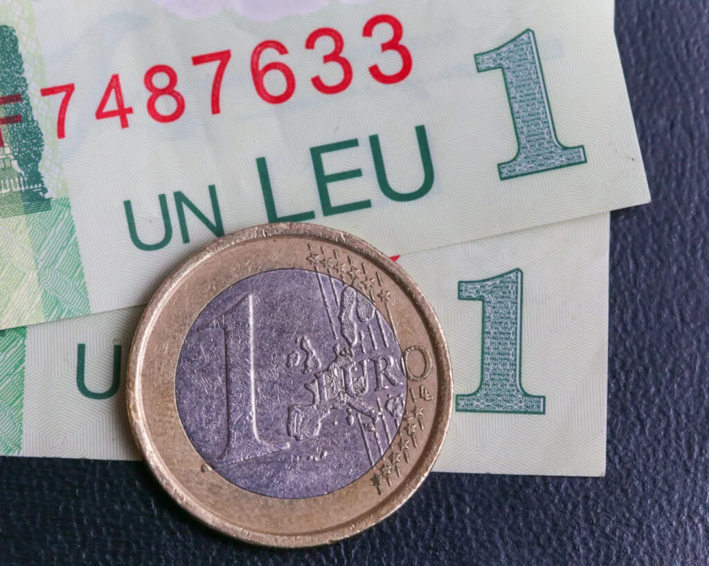 Bancnote de leu și euro, simbolizând volatilitatea cursului valutar.