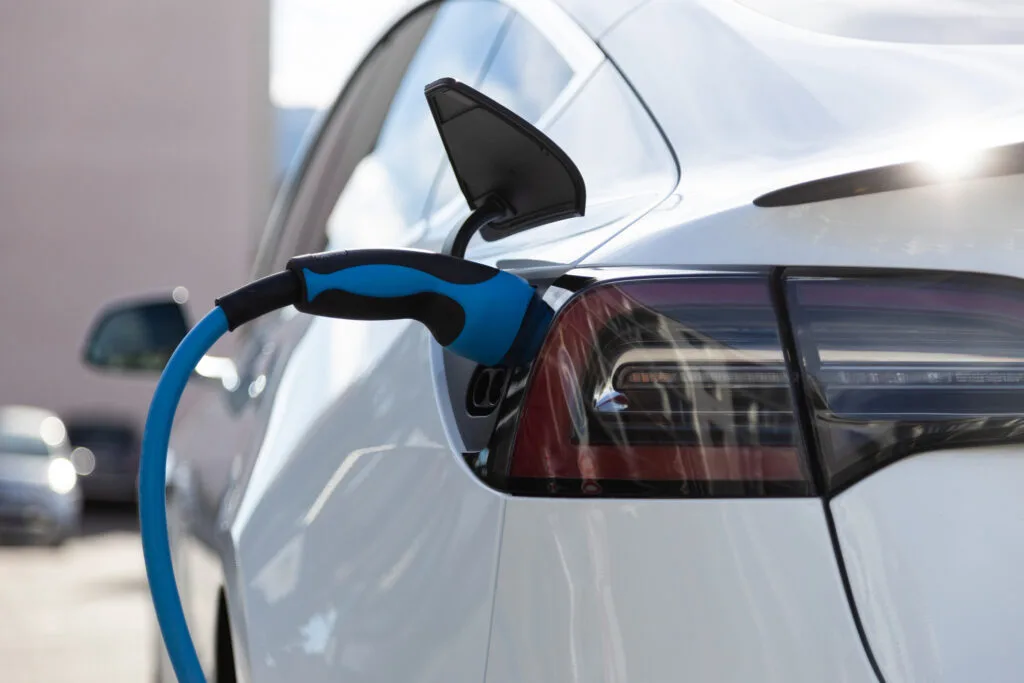 Încărcare de mașină electrică, simbol al tranziției ecologice în auto.