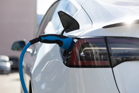 Încărcare de mașină electrică, simbol al tranziției ecologice în auto.