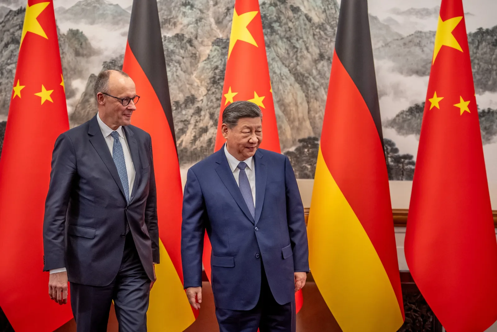 Friedrich Merz și Xi Jinping discutând în fața steagurilor Germaniei și Chinei.