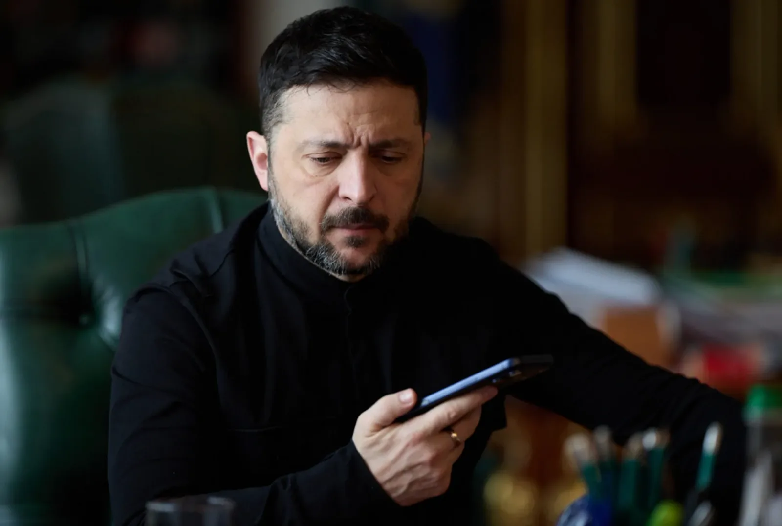 Zelenski ascultând un apel telefonic important în birou.