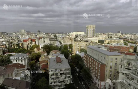 Peisaj urban cu clădiri și cer noros în fundal.