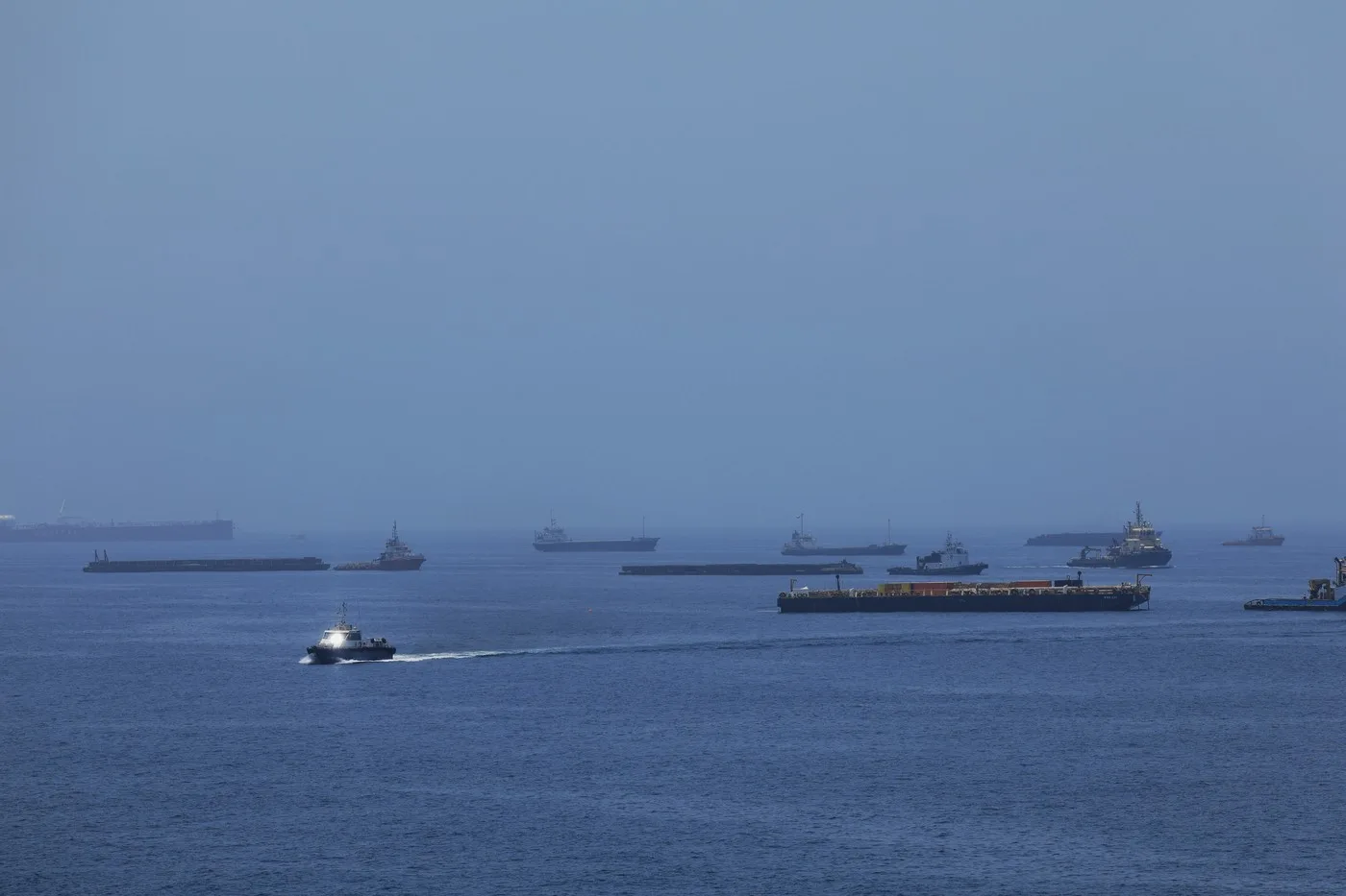 Nave comerciale navigând prin Strâmtoarea Ormuz, cu un peisaj maritim liniștit.