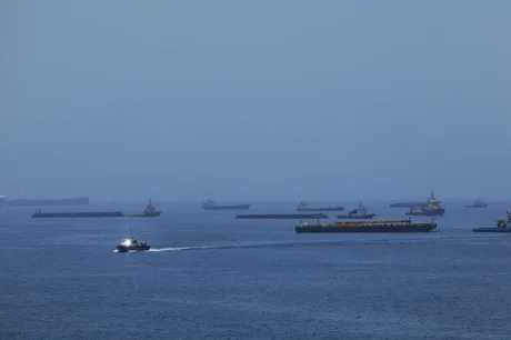 Nave comerciale navigând prin Strâmtoarea Ormuz, cu un peisaj maritim liniștit.