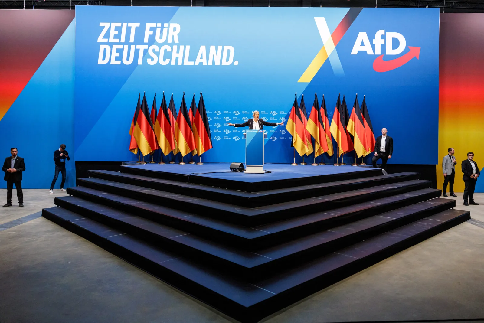 Scenă cu steaguri germane, simbolizând tensiuni politice în Germania.