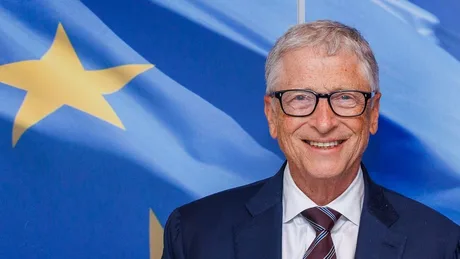 Bill Gates discutând despre siguranța inteligenței artificiale în fața unei drapele.