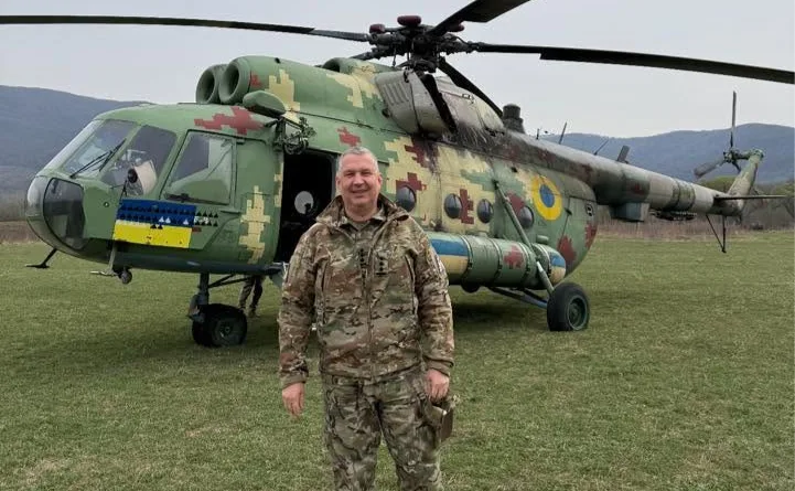 Pavlo Yelizarov în uniformă militară, lângă un elicopter de luptă.