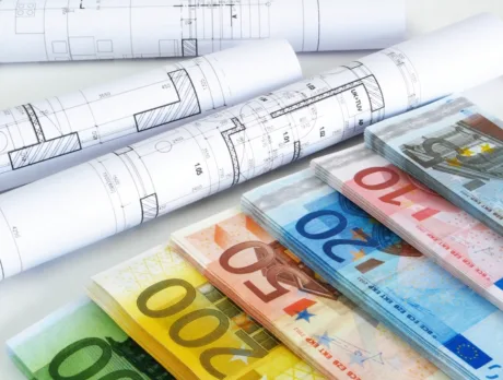 Bancnote euro alături de planuri arhitecturale pentru startup-uri inovatoare.