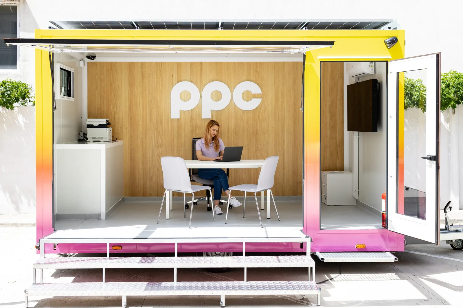 Un birou mobil modern, cu logo PPC, utilizat pentru servicii energetice.
