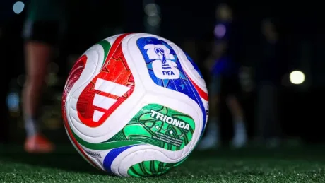 Trofeul Cupei Mondiale 2026 alături de bilete și un telefon.
