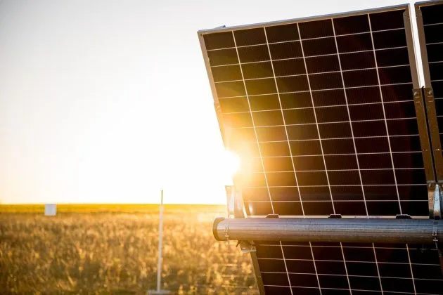 Panouri solare captând lumina soarelui într-un peisaj rural din România.