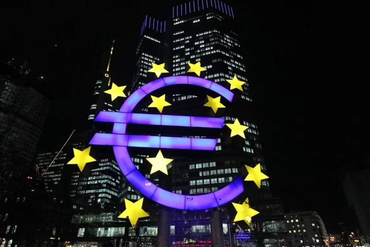 Simbolul euro iluminat noaptea, reprezentând Banca Centrală Europeană.