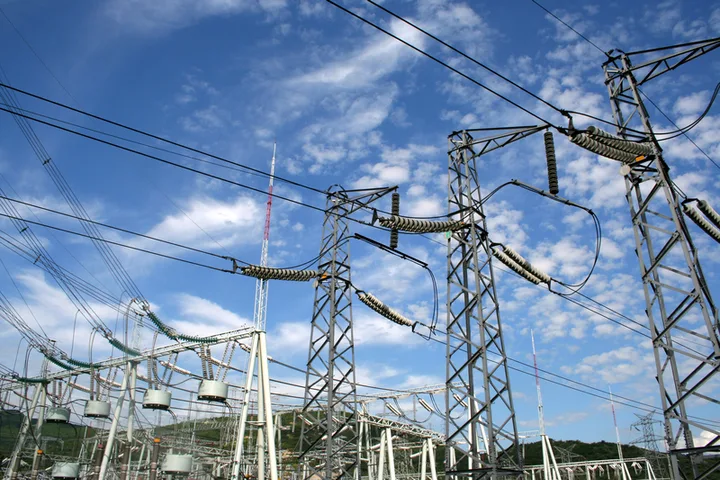 Rețea electrică cu stâlpi și cer senin, simbolizând exportul de energie.