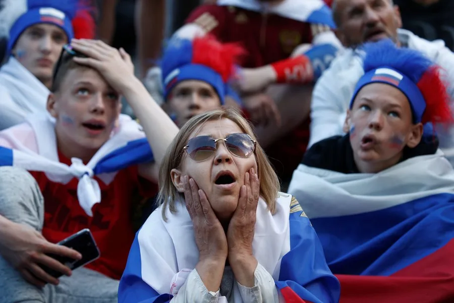 Suporteri ruși cu steaguri, exprimându-și emoțiile intense.