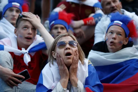 Suporteri ruși cu steaguri, exprimându-și emoțiile intense.