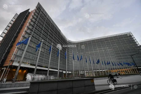 Clădirea Comisiei Europene cu steaguri, simbolizând cooperarea internațională.