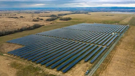 Centrale fotovoltaice amplasate pe un teren vast în România, cu panouri solare aranjate ordonat.