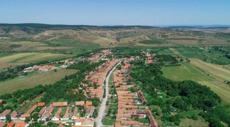 Vedere panoramică a satului Viscri, cu case tradiționale și peisaje rurale.
