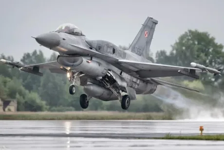 Avion militar polonez decolând pe un aeroport umed.